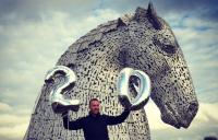 Photo of Chris Hoy standing in front of The Kelpies sculpture