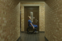 A woman in a wheelchair in a corridor