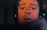 Still from the film of a man wearing headphones