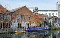 Photo of a canal boat by a warehouse