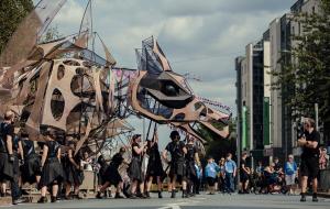 a giant dragon puppet handled by multiple puppeteers