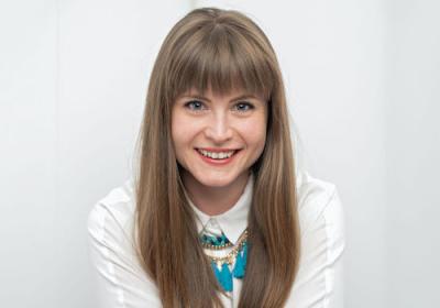 Susannah Stevenson smiles in front of a white background