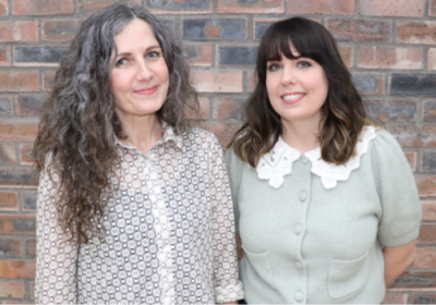 Maria Thelwell and Charli Ward stand in front of a brick wall