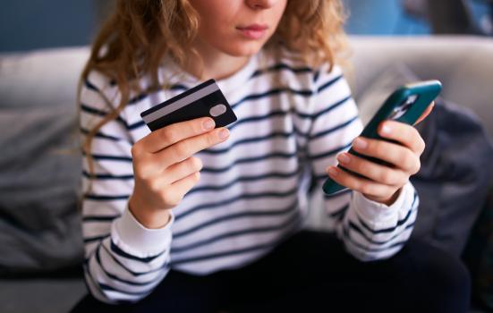 Worried woman with smartphone and debit card