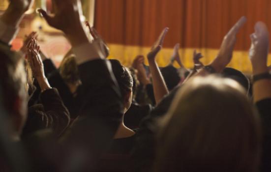 A theatre audience clapping