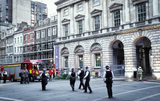 The Strand Street In Central London, England, United Kingdom, August 17, 2024,Street: Strand; District: Covent Garden; Borough: City of Westminster; County: Greater London. fire trucks are parked at Somerset House public square, in daytime late afternoon in summer time, there are several Metropolitan police officers and firemen. Police officers and firemen and fire trucks.