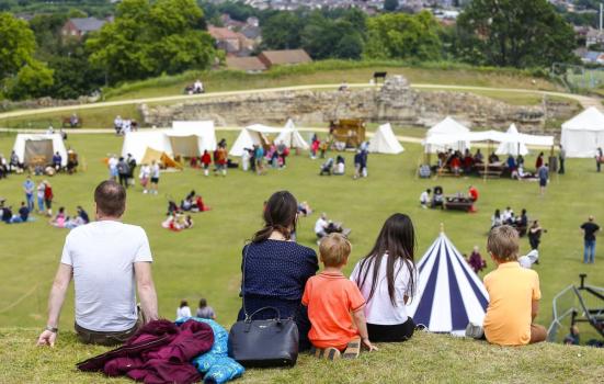 People sitting on the grass in the grounds of Pontefract Castle