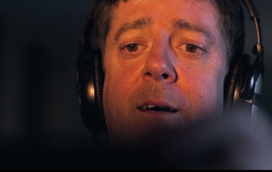 Still from the film of a man wearing headphones