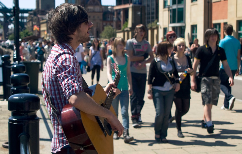 Photo of man playing guitar on the street