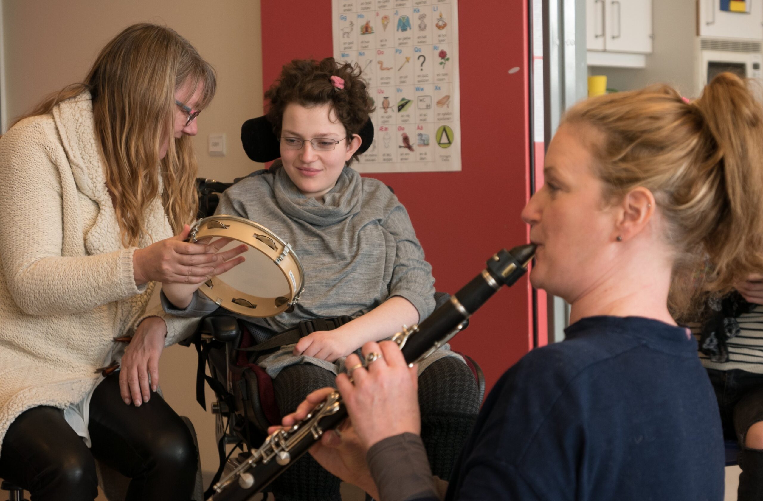 Image of clarinetist & young woman in wheelchair with tambourine