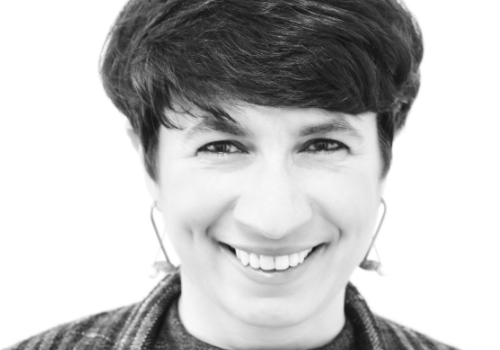 Viviana Checcia, Director of Void Gallery. A black and white headshot. Checcia has short brown hair, and wears long earrings. She is smiling at the camera.