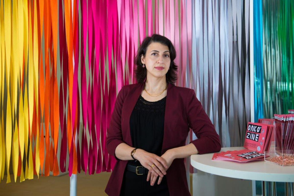 Yasmin Kan stands in front of a rainbow curtain