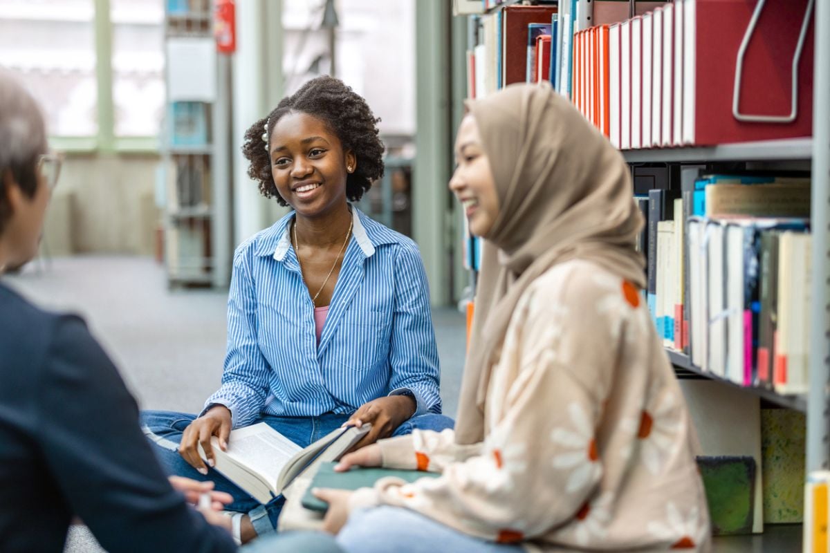 Group of students sitting in a library and studying together stock photo iStock